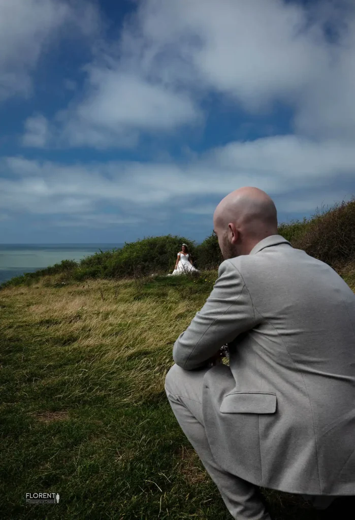 Séance photographie mariage sur la falaise le marie voit au loin sa belle vue sur le mer studio florent boulogne sur mer lille le touquet amiens saint omer dunkerque hardelot paris