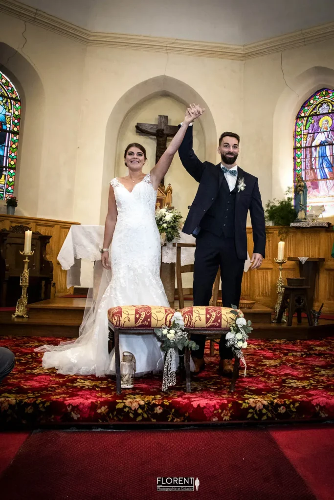 les époux sont heureux de lever les bras pour montrer leur alliance à l'église copie