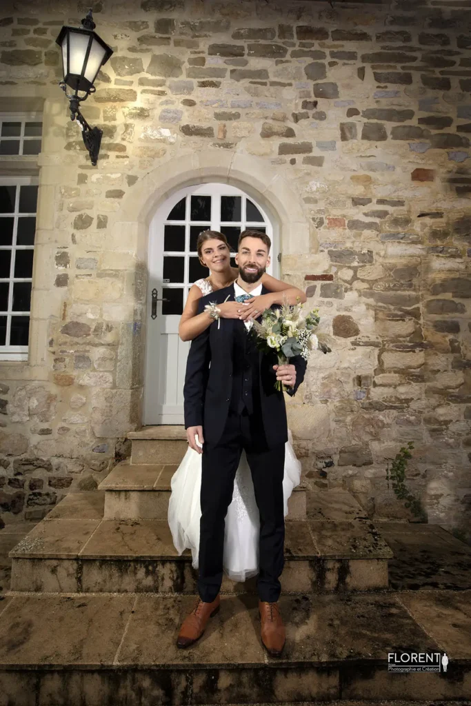 photo devant la demeure en pierre les mariés posent copie