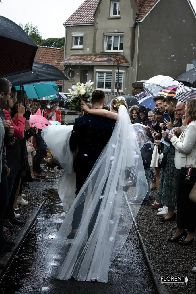photographe mariage a lille marie porte mariee souriante sous la pluie entoures des temoins florent studio photographe boulogne sur mer lille calais saint omer le touquet paris bethune