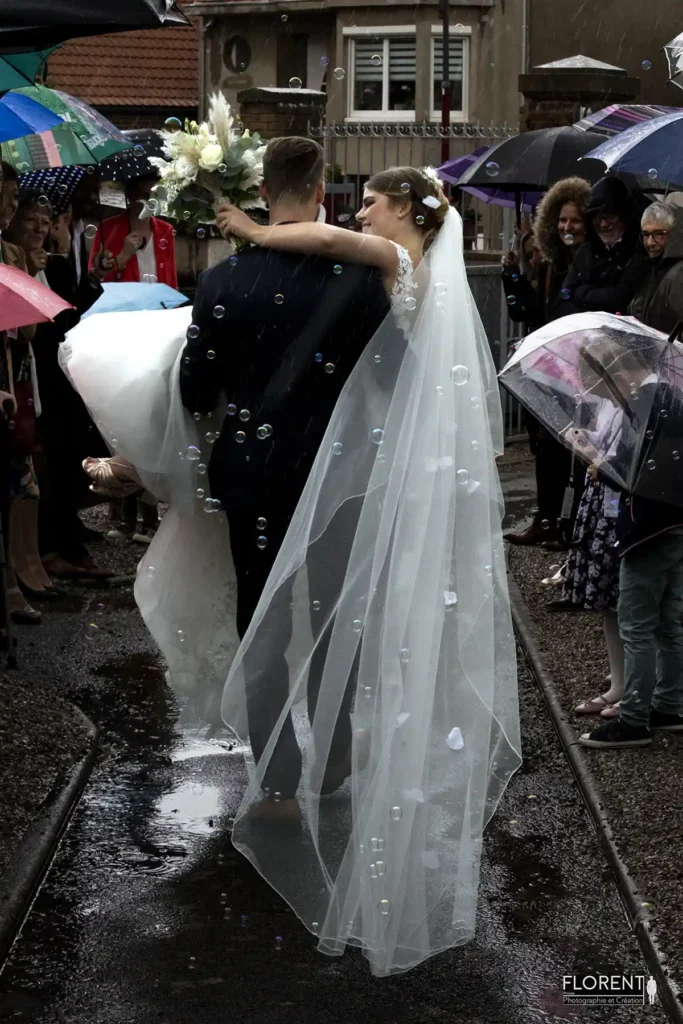 photographe mariage lille des marie porte mariee souriante sous la pluie entoures des temoins florent studio photographe boulogne sur mer lille calais saint omer le touquet paris france bethune