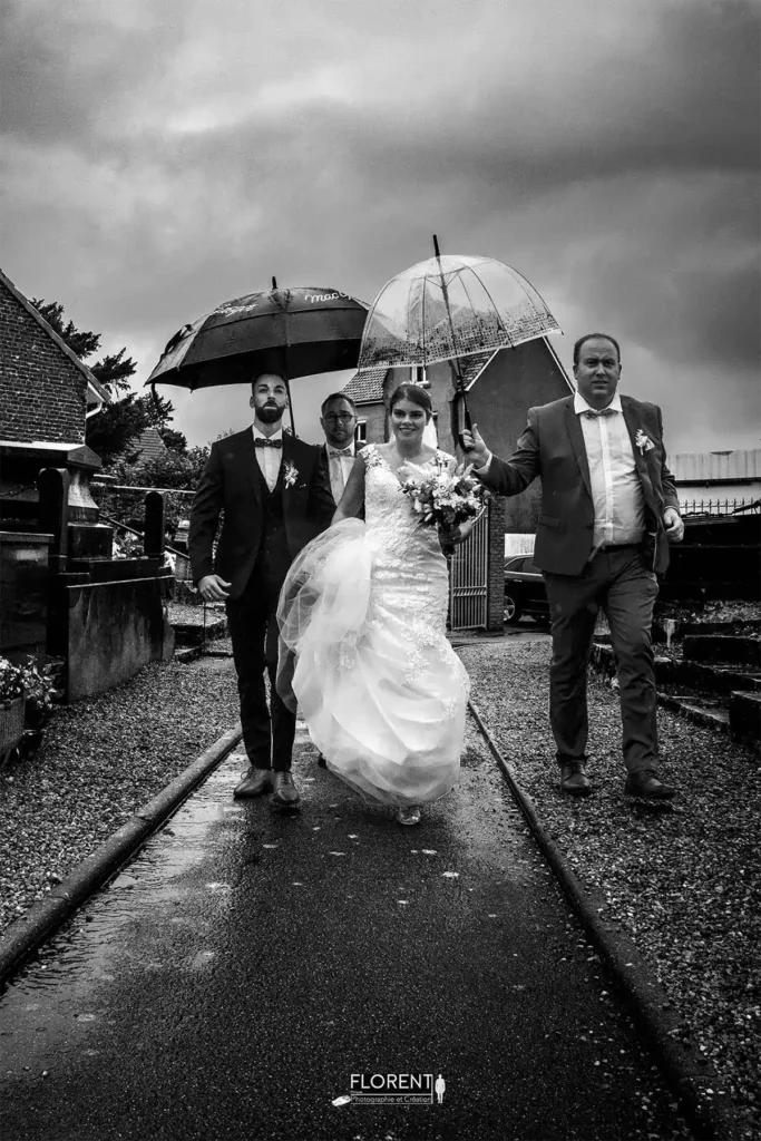 photographe mariage lille des maries arrivant à l'église sous la pluie entourés des témoins florent studio photographe boulogne sur mer lille calais saint omer le touquet paris france bethune