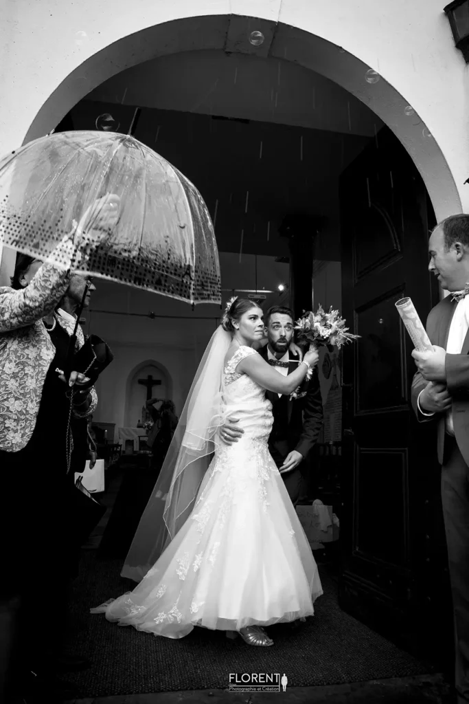 photographe mariage lille des maries sortent eglise sous la pluie entoures des temoins florent studio photographe boulogne sur mer lille calais saint omer le touquet paris france bethune