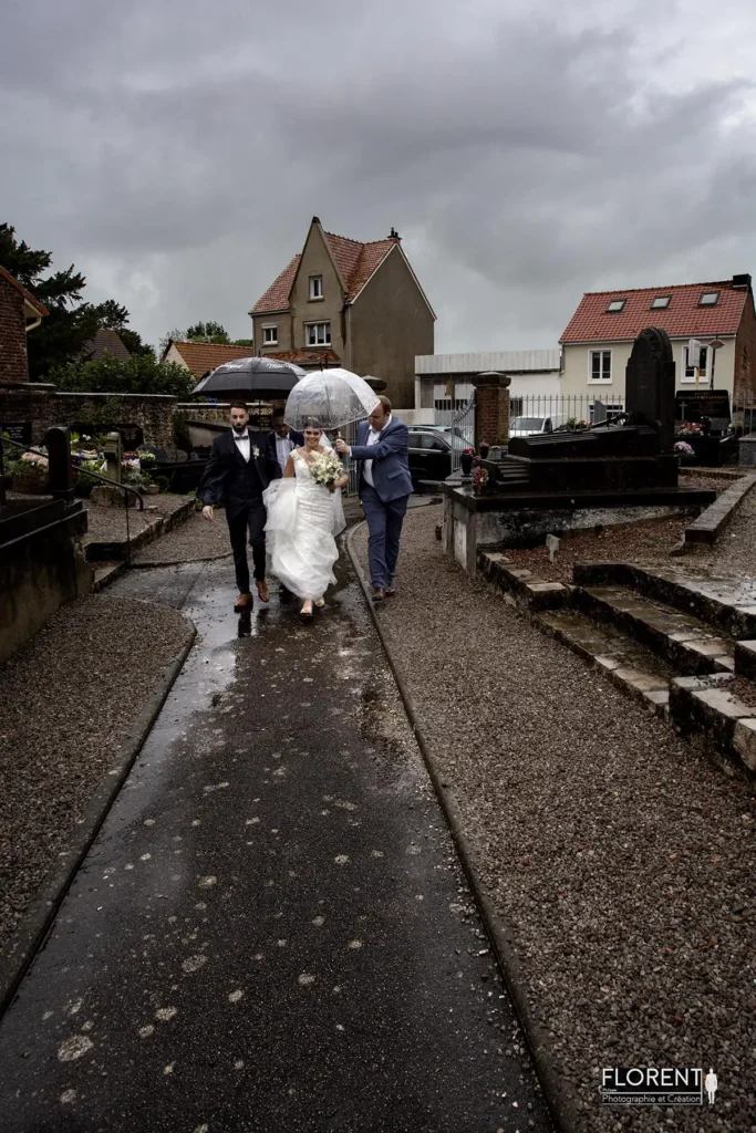 superbe photo des mariés arrivant à l'église en courant sous la pluie entourés des témoins florent studio fanie photographe boulogne sur mer lille calais saint omer le touquet paris france