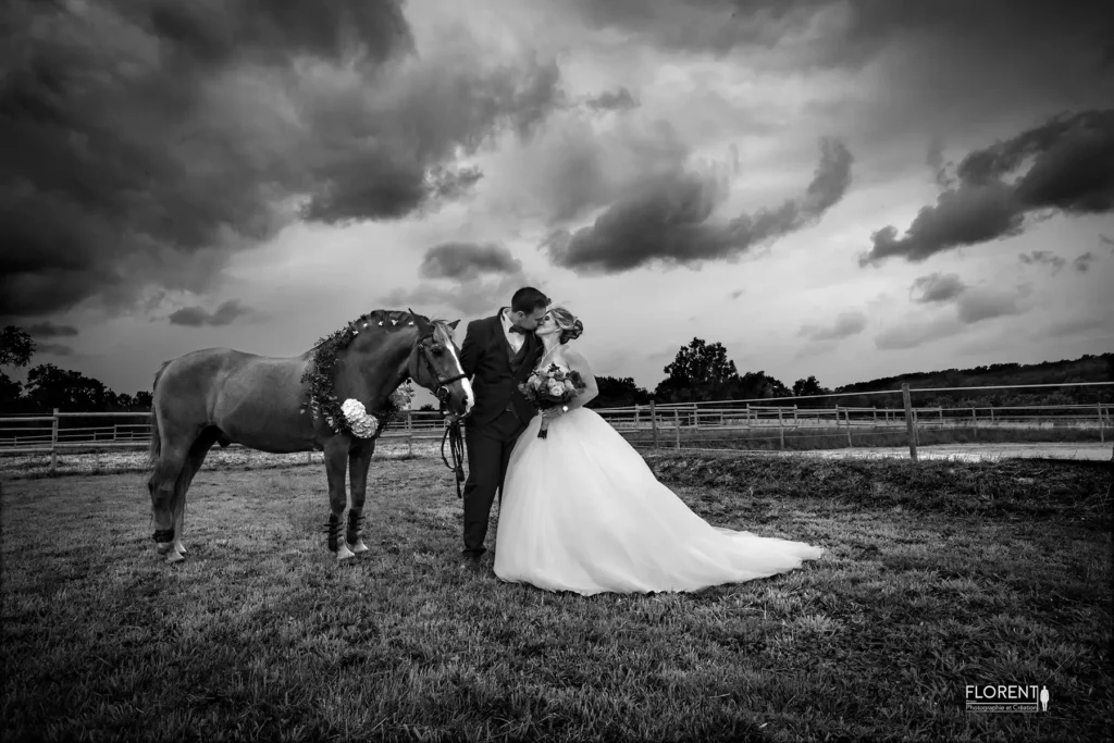 mariage impressionnant saint omer les maries s'embrasse avec leur cheval sous la pluie au milieu du manege studio photographe mariage pas de calais nord boulogne sur mer lille paris arras calais