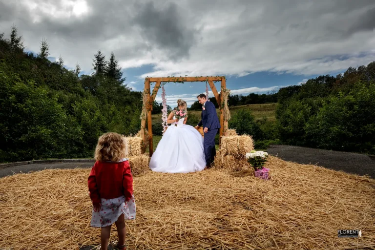 mariage petite fille regarde pose tendre epoux sur balançelle saint omer florent studio photographe mariage pas de calais nord boulogne sur mer lille paris arras le touquet