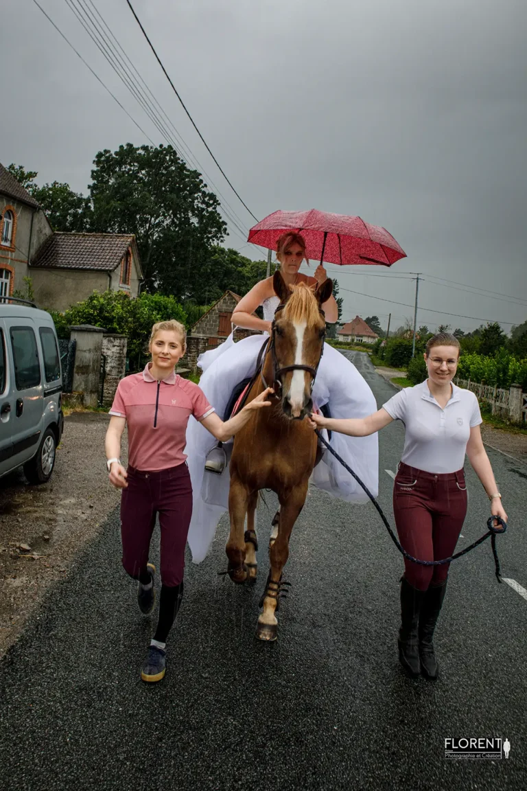 mariee saint omer a cheval et parapluie avec ecuilleres souriantes sous l'orage florent studio photographe mariage pas de calais nord boulogne sur mer lille paris hardelot arras le touquet desvres