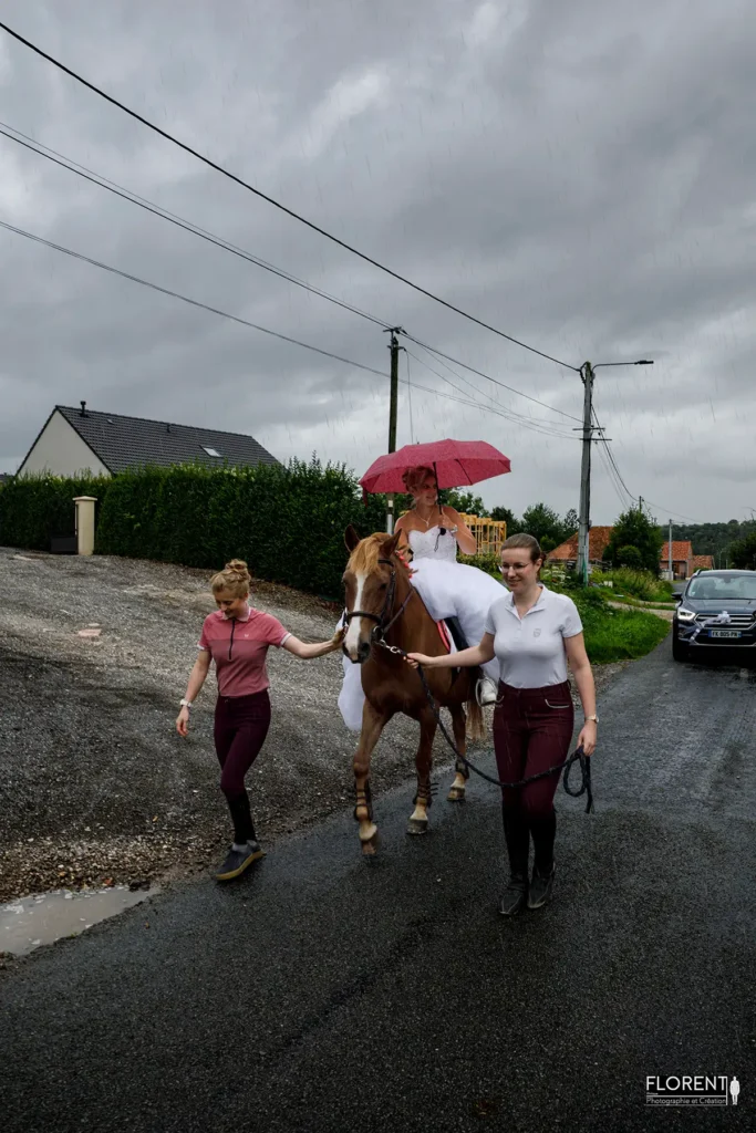 mariee saint omer a cheval et parapluie devant la mairie cheval sous la pluie et amies florent studio photographe mariage pas de calais nord boulogne sur mer lille paris hardelot arras le touquet