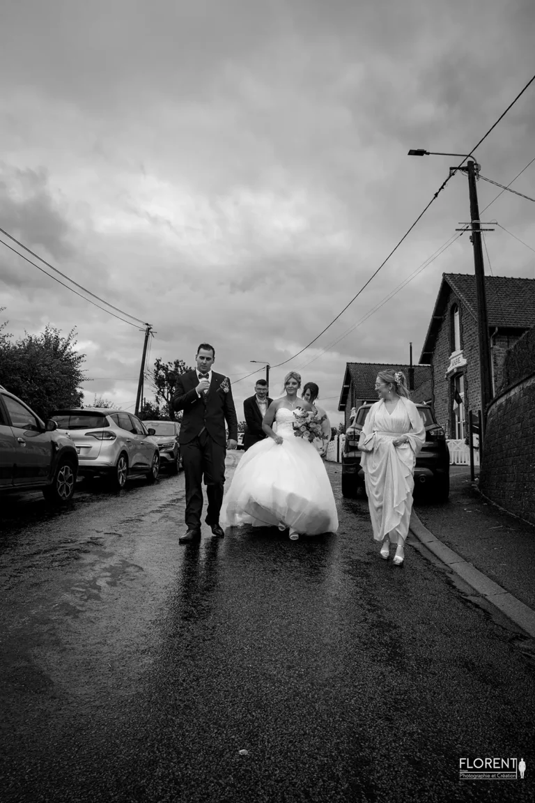 photo mariage arrivee sous la pluie au milieu village epoux chapelle saint omer florent studio photographe mariage pas de calais nord boulogne sur mer lille paris arras le touquet