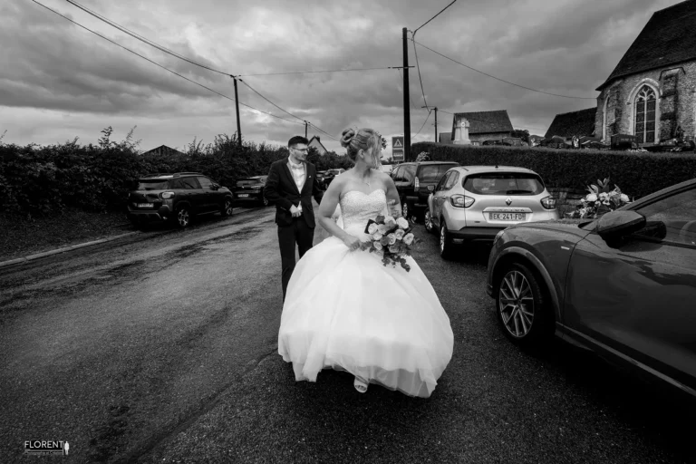 photo mariage arrivee sous la pluie et ciel noir au milieu village epoux chapelle saint omer florent studio photographe mariage pas de calais nord boulogne sur mer lille paris arras le touquet