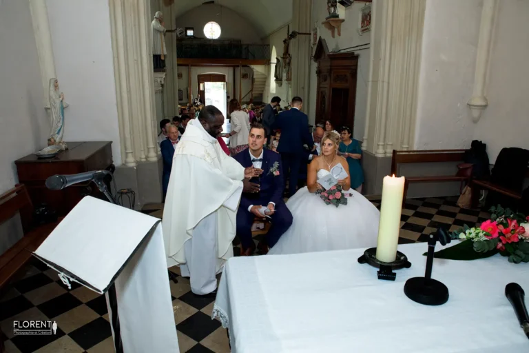 photo mariage coeur de l eglise derriere autel vue sur maries et pretre parle saint omer florent studio photographe mariage pas de calais nord boulogne sur mer lille paris arras le touquet