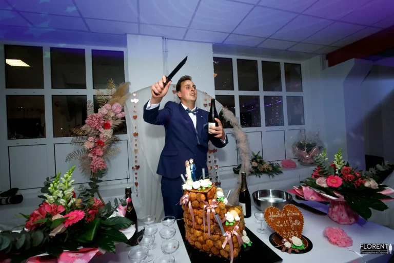 photographe mariage le maries sabre le champagne derriere gateau florent saint omer studio photographe mariage pas de calais nord boulogne sur mer lille paris arras le touquet