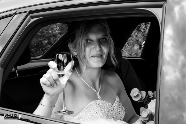 photographe mariage saint omer la mariee souriante dans la voiture avec coupe de champagne studio photographe mariage pas de calais nord boulogne sur mer lille paris arras le touquet desvres