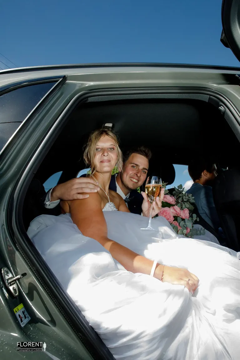 photographe mariage saint omer les maries souriants dans la voiture avec coupe de champagne studio photographe mariage pas de calais nord boulogne sur mer desvres lille paris arras le touquet