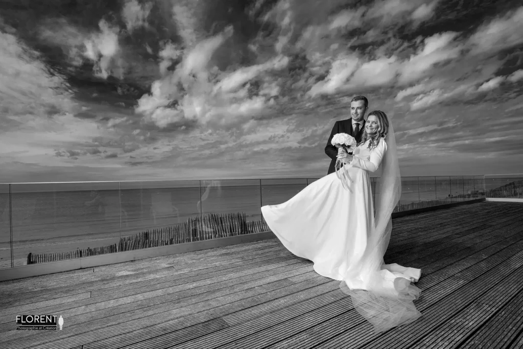 mariage epoux pose renversante souriante terrasse novotel fond ciel bleu plage le touquet florent photographe mariage le touquet paris saint omer lille boulogne sur mer