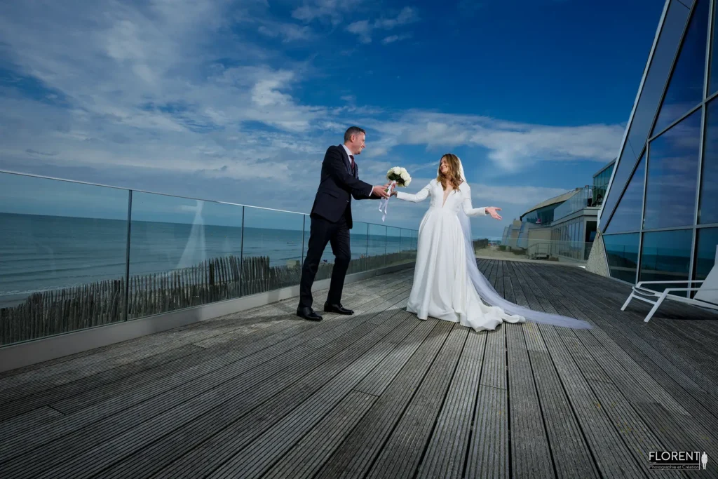 pose mariage epoux tend bouquet terrasse novotel ciel bleu plage le touquet florent photographe mariage le touquet paris saint omer lille boulogne sur mer