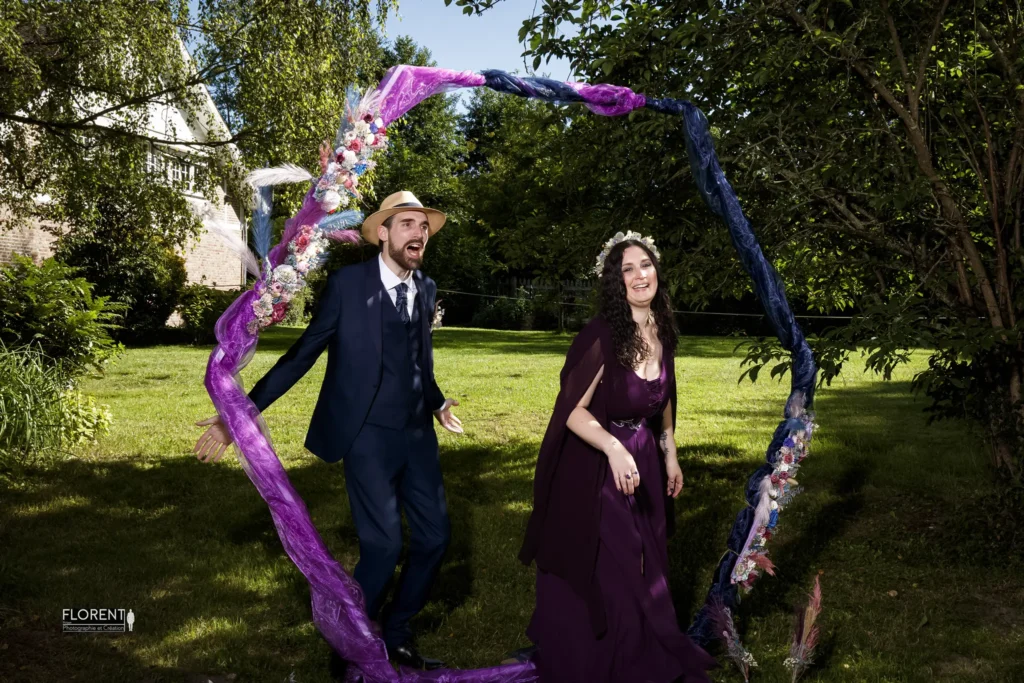 mariage ceremonie laique foret epoux courts en souriant sous un arche mauve florent studio