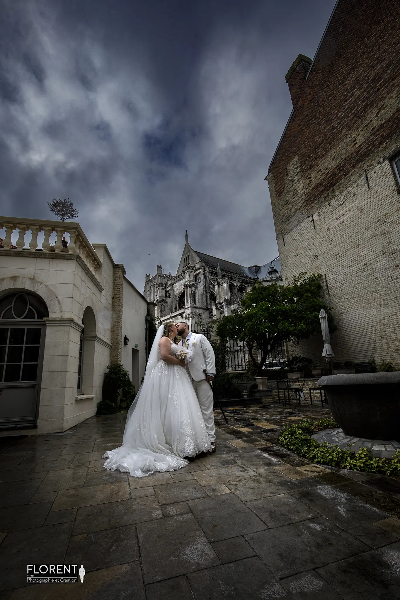 mariage-epoux-s-embrasse-sous-la-pluie-saint-omer-vue-sur-la-cathedrale-clos-bailli-florent-studio