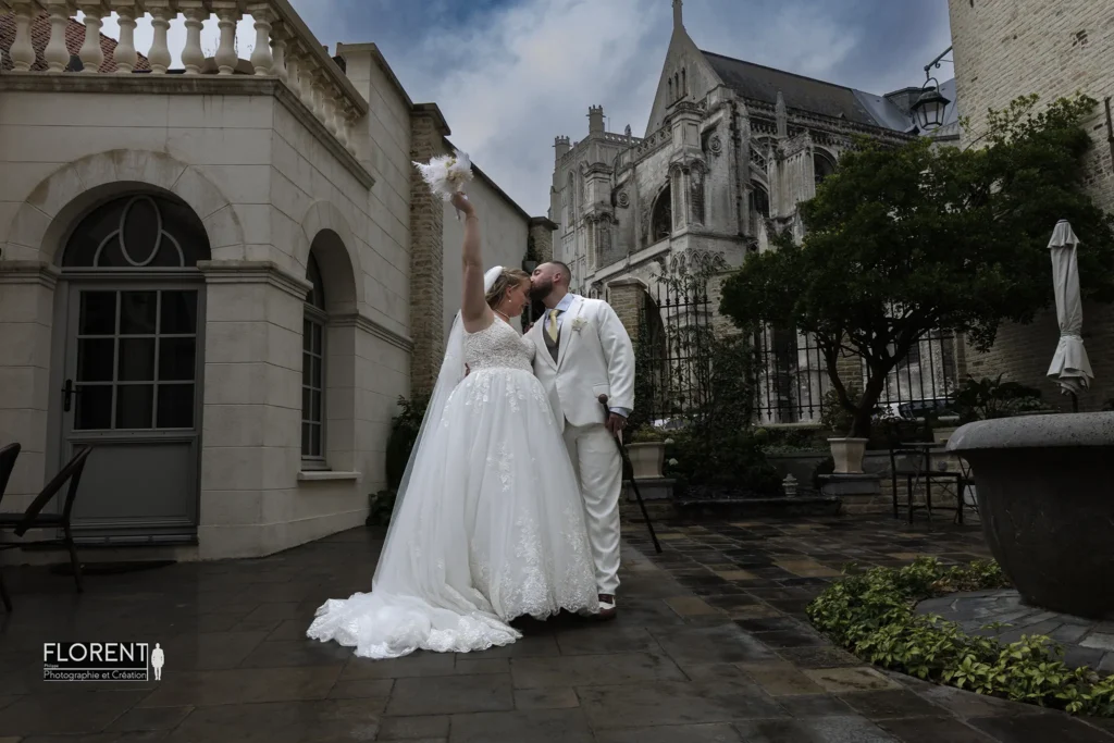 mariage-joyeux-saint-omer-clos-bailli-vue-sur-la-cathedrale-sous-la-pluie-epoux-s-embrasse-la-marie-jette-son-bouquet-florent-studio